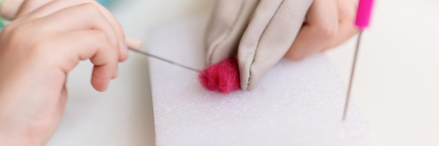 ręce trzymające igłę i materiał